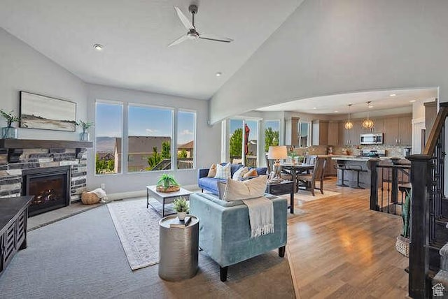 735 W Horizon Dr, Lehi, UT 84043 - living area with ceiling fan, a stone fireplace, light wood-style flooring, high vaulted ceiling, and recessed lighting