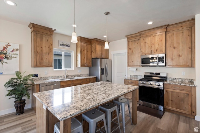 7982 N Bristlecone Rd, Eagle Mountain, UT 84005 - kitchen featuring stainless steel appliances, light wood finished floors, a breakfast bar, light stone counters, and recessed lighting