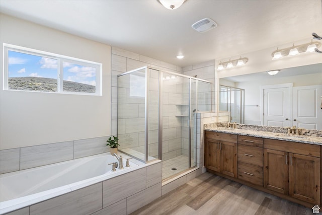 7982 N Bristlecone Rd, Eagle Mountain, UT 84005 - bathroom featuring a shower stall, a bath, double vanity, and wood finished floors