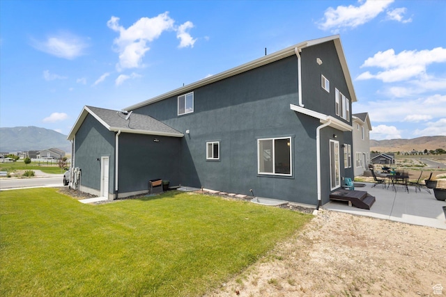 7982 N Bristlecone Rd, Eagle Mountain, UT 84005 - rear view of house featuring a mountain view, a patio, a yard, and stucco siding