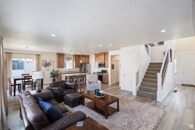 7982 N Bristlecone Rd, Eagle Mountain, UT 84005 - living area featuring light wood-type flooring, stairway, recessed lighting, and a chandelier