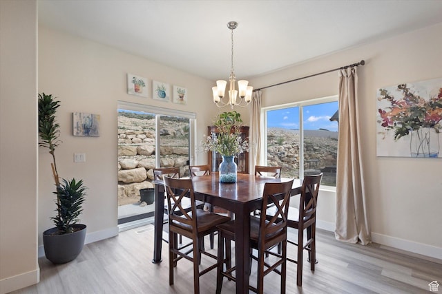 7982 N Bristlecone Rd, Eagle Mountain, UT 84005 - dining room featuring a chandelier, light wood-style floors, and plenty of natural light