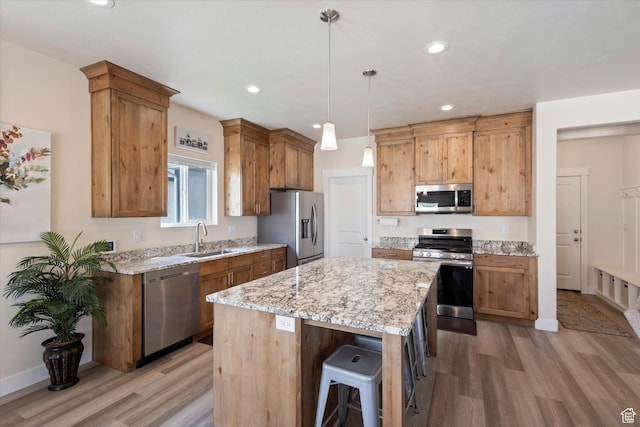 7982 N Bristlecone Rd, Eagle Mountain, UT 84005 - kitchen featuring stainless steel appliances, light wood finished floors, a kitchen island, light stone countertops, and recessed lighting