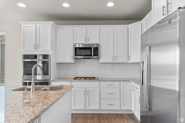 1298 E Salt Creek Peak, Eagle Mountain, UT 84005 - kitchen featuring appliances with stainless steel finishes, white cabinetry, dark wood finished floors, recessed lighting, and light stone counters