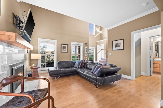 369 E 9th Ave, Salt Lake City, UT 84103 - living room featuring light wood-style flooring, ornamental molding, and a lit fireplace