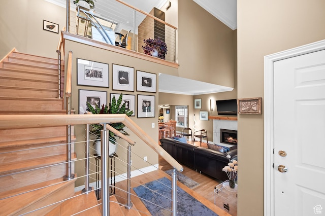 369 E 9th Ave, Salt Lake City, UT 84103 - stairway with ornamental molding, a towering ceiling, a lit fireplace, and wood finished floors