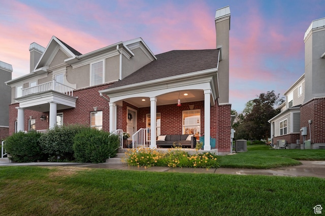 369 E 9th Ave, Salt Lake City, UT 84103 - view of front facade with brick siding, outdoor lounge area, a yard, and a chimney
