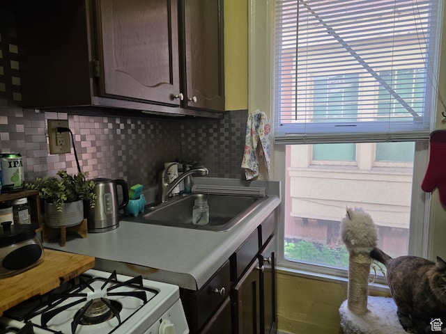 423 E 1st Ave N, Salt Lake City, UT 84103 - kitchen with tasteful backsplash, white range with gas cooktop, light countertops, and dark brown cabinetry