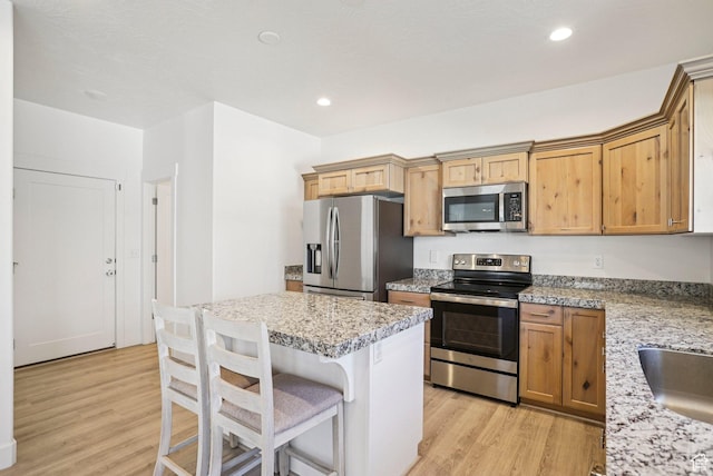 7215 N Clear Meadow Way, Eagle Mountain, UT 84005 - kitchen featuring stainless steel appliances, light wood-type flooring, a kitchen bar, a center island, and recessed lighting