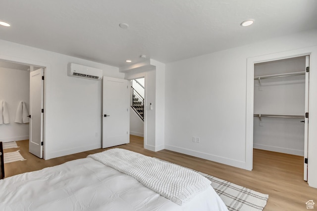 4186 S Main St Unit O217, Millcreek, UT 84107 - bedroom with a wall mounted AC, a walk in closet, recessed lighting, wood finished floors, and a closet
