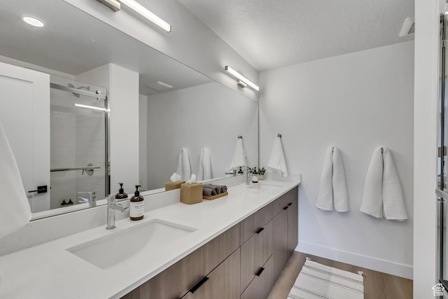 4186 S Main St Unit O217, Millcreek, UT 84107 - bathroom featuring double vanity, a tile shower, wood finished floors, and recessed lighting