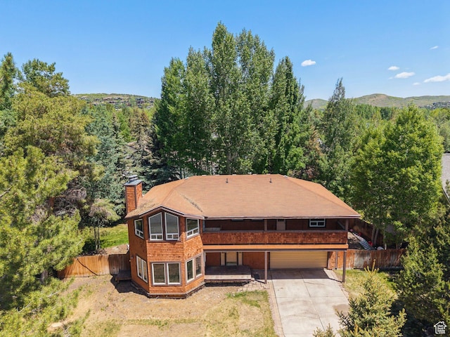 754 Quaking Aspen Ct, Park City, UT 84060 - view of front of home featuring a chimney, concrete driveway, a forest view, and a garage