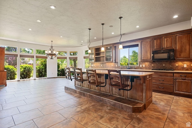 1285 Summerwood Cir, Santa Clara, UT 84765 - kitchen featuring black appliances, recessed lighting, tasteful backsplash, light countertops, and a kitchen breakfast bar