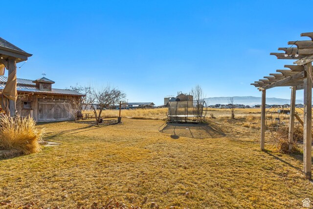 338 S Holdaway Rd, Vineyard, UT 84059 - view of grassy yard featuring a trampoline and a pergola
