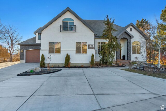 338 S Holdaway Rd, Vineyard, UT 84059 - french provincial home with stone siding, driveway, stucco siding, and a balcony