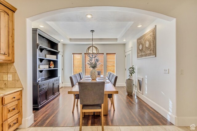 338 S Holdaway Rd, Vineyard, UT 84059 - dining area featuring dark wood finished floors, a chandelier, a raised ceiling, arched walkways, and recessed lighting