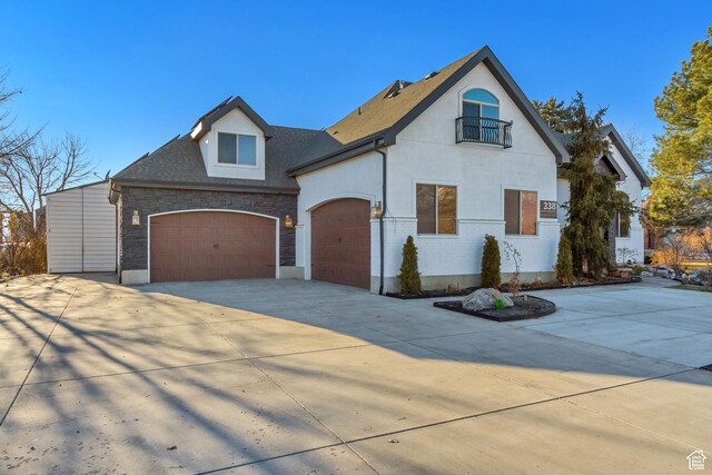 338 S Holdaway Rd, Vineyard, UT 84059 - french country inspired facade with concrete driveway, stone siding, an attached garage, and a balcony
