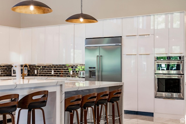 1621 E Box Elder Cir, Alpine, UT 84004 - kitchen with stainless steel appliances, modern cabinets, light stone countertops, and a kitchen bar