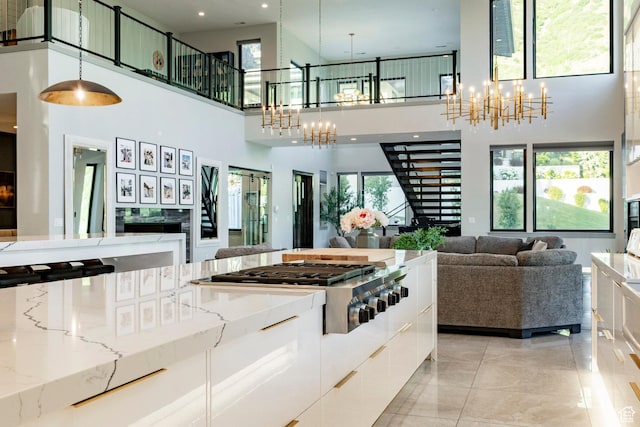 1621 E Box Elder Cir, Alpine, UT 84004 - kitchen with a chandelier, open floor plan, a towering ceiling, white cabinets, and plenty of natural light