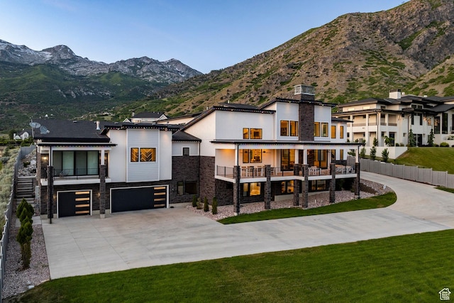 1621 E Box Elder Cir, Alpine, UT 84004 - view of front of house featuring stone siding, a balcony, driveway, a garage, and a mountain view