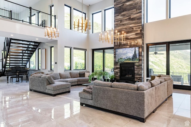 1621 E Box Elder Cir, Alpine, UT 84004 - living room featuring a chandelier, a towering ceiling, a stone fireplace, stairs, and marble finish floors