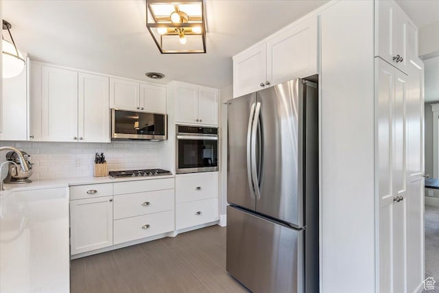 1393 E Davis Ave, Logan, UT 84321 - kitchen featuring appliances with stainless steel finishes, white cabinetry, light countertops, and decorative backsplash