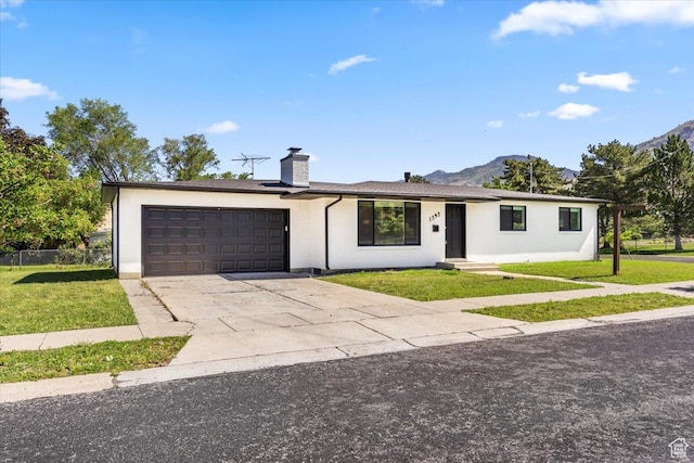 1393 E Davis Ave, Logan, UT 84321 - ranch-style house with an attached garage, a chimney, driveway, and a mountain view
