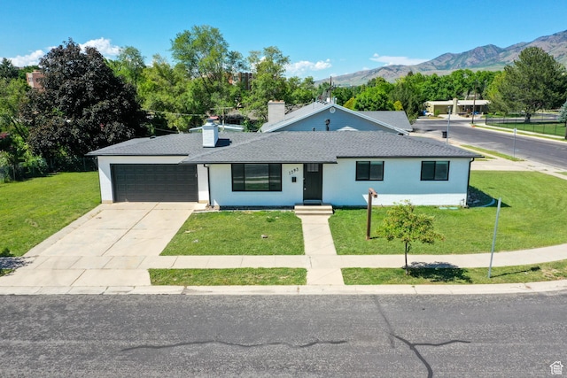 1393 E Davis Ave, Logan, UT 84321 - view of front of home featuring a front yard, a garage, a mountain view, and concrete driveway