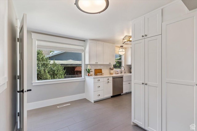 1393 E Davis Ave, Logan, UT 84321 - kitchen featuring dishwasher, healthy amount of natural light, white cabinets, and light countertops
