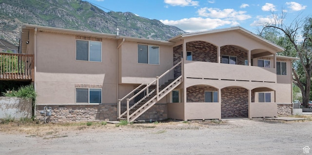 9096 N Canyon Rd, Cedar Hills, UT 84062 - view of front facade featuring a mountain view, stucco siding, stairway, stone siding, and a balcony