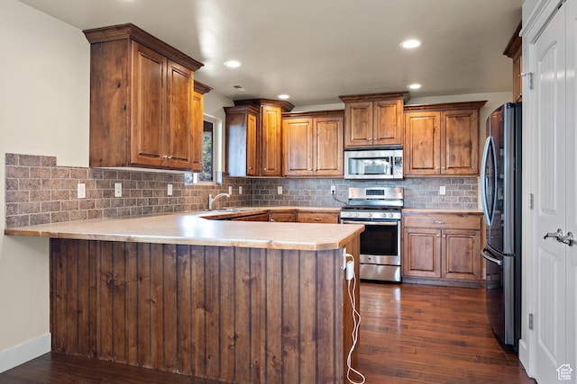 9096 N Canyon Rd, Cedar Hills, UT 84062 - kitchen featuring stainless steel appliances, a peninsula, light countertops, dark wood-style flooring, and brown cabinets
