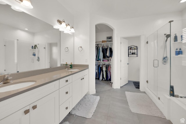 4655 N Ibapah St, Eagle Mountain, UT 84005 - bathroom featuring a shower stall, double vanity, tile patterned flooring, a walk in closet, and recessed lighting