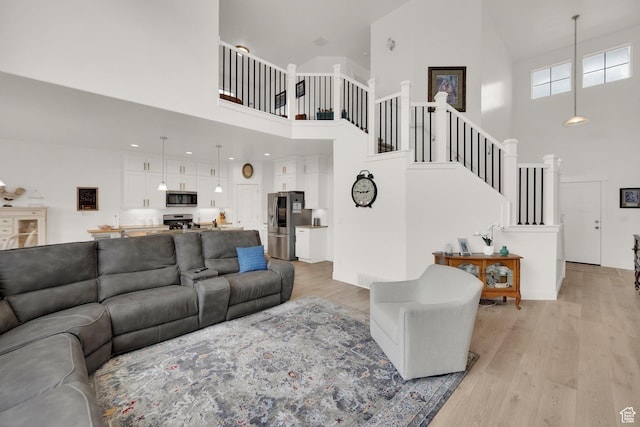 4655 N Ibapah St, Eagle Mountain, UT 84005 - living room with high vaulted ceiling, light wood finished floors, and stairway