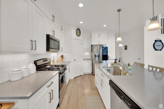4655 N Ibapah St, Eagle Mountain, UT 84005 - kitchen featuring stainless steel appliances, recessed lighting, light wood-style flooring, tasteful backsplash, and hanging light fixtures