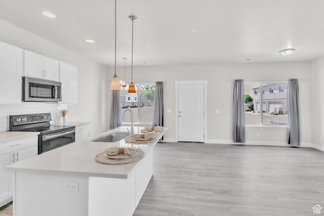 797 S Cowans Ct, Clearfield, UT 84015 - kitchen featuring stainless steel appliances, light wood finished floors, light countertops, white cabinetry, and decorative backsplash