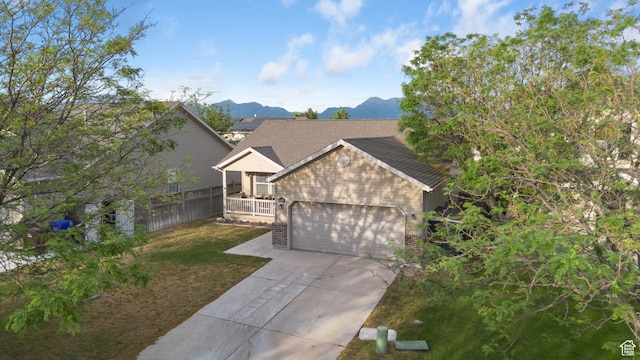 7114 N Ute Dr Unit 70, Eagle Mountain, UT 84005 - view of front facade featuring an attached garage, driveway, a front yard, brick siding, and a mountain view