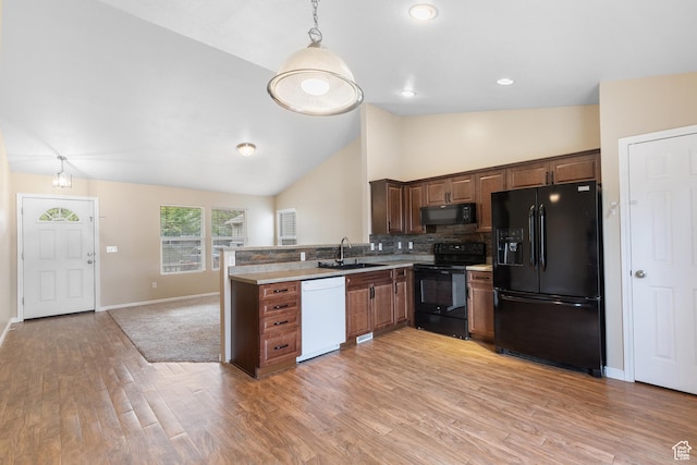7114 N Ute Dr Unit 70, Eagle Mountain, UT 84005 - kitchen with black appliances, light wood-style floors, decorative backsplash, hanging light fixtures, and light countertops