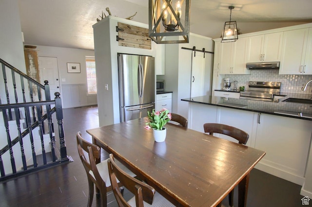 1657 N Lewis And Clark Dr, Centerville, UT 84014 - dining area with a barn door, dark wood finished floors, stairs, and a wainscoted wall