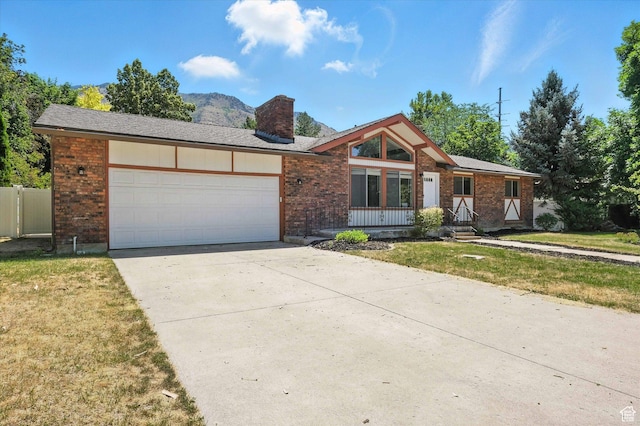 1520 N 1600 E, North Logan, UT 84341 - view of front of house featuring a chimney, brick siding, an attached garage, driveway, and a front lawn