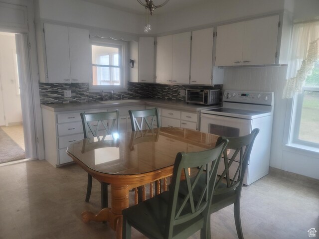279 E 50 N, Moroni, UT 84646 - kitchen with stove, tasteful backsplash, white cabinetry, and light floors