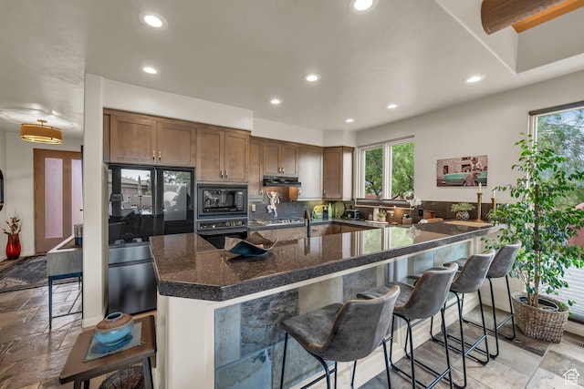 2255 Tuweap Dr N Unit 54, St George, UT 84770 - kitchen with black appliances, recessed lighting, a kitchen breakfast bar, extractor fan, and dark stone counters