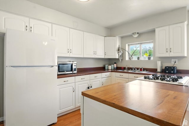302 S 100 E, Logan, UT 84321 - kitchen with white appliances, white cabinetry, a peninsula, and light wood-type flooring