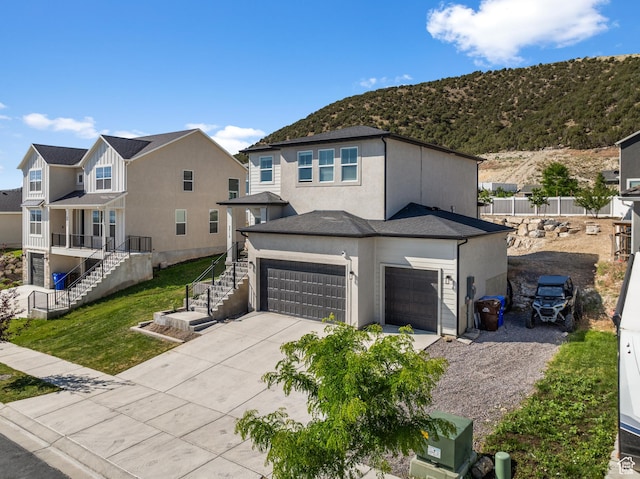 3712 E Long Ridge Dr Unit 124, Eagle Mountain, UT 84005 - view of front facade with stairway, concrete driveway, a residential view, a mountain view, and stucco siding