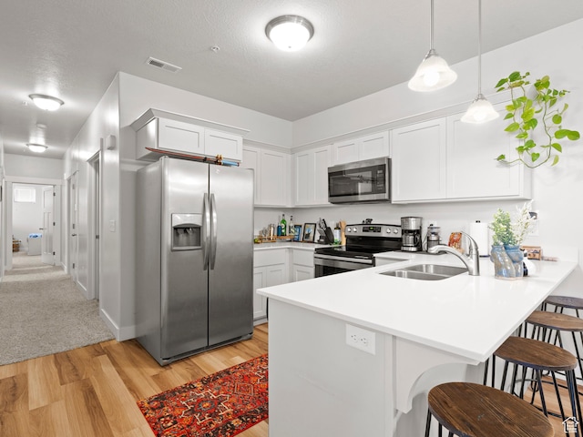 3795 W 2280 N Unit A201, Lehi, UT 84043 - kitchen with stainless steel appliances, a peninsula, light wood-type flooring, a kitchen breakfast bar, and light countertops