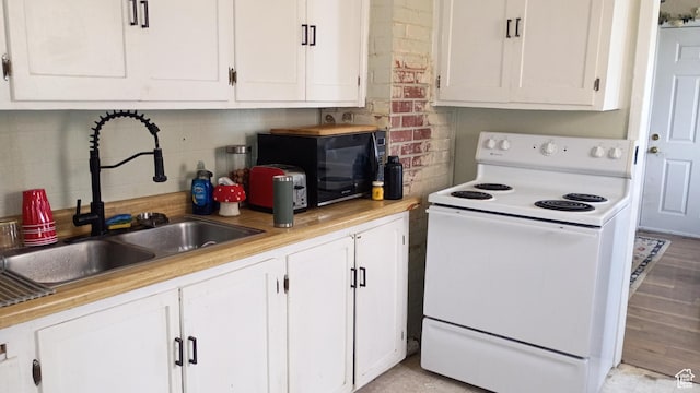 131 6th W, East Carbon, UT 84520 - kitchen with electric stove, white cabinets, black microwave, and light countertops