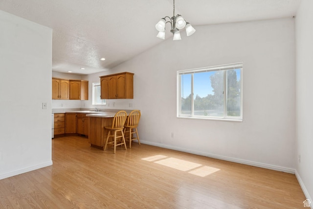 827 S 1030 W, Richfield, UT 84701 - kitchen featuring a chandelier, light wood-style flooring, a breakfast bar, light countertops, and a peninsula