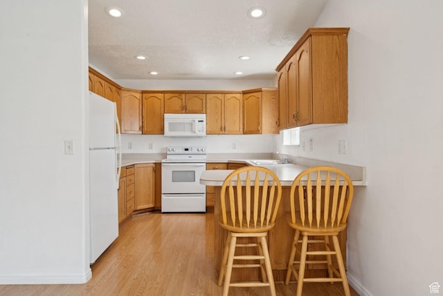 827 S 1030 W, Richfield, UT 84701 - kitchen featuring white appliances, a peninsula, light wood finished floors, recessed lighting, and light countertops