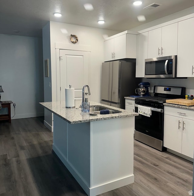 470 W 15 S Unit F201, Providence, UT 84332 - kitchen with stainless steel appliances, wood finished floors, light stone counters, an island with sink, and white cabinets