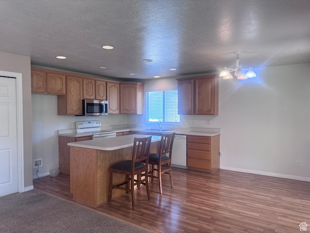 1730 N 350 W, North Ogden, UT 84414 - kitchen featuring white appliances, a kitchen island, light countertops, wood finished floors, and a kitchen breakfast bar