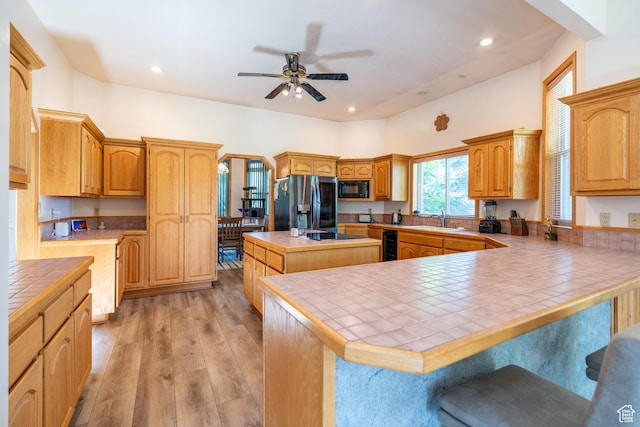 4163 S Beeman Rd, Moab, UT 84532 - kitchen featuring refrigerator with ice dispenser, black microwave, tile countertops, ceiling fan, and a kitchen island